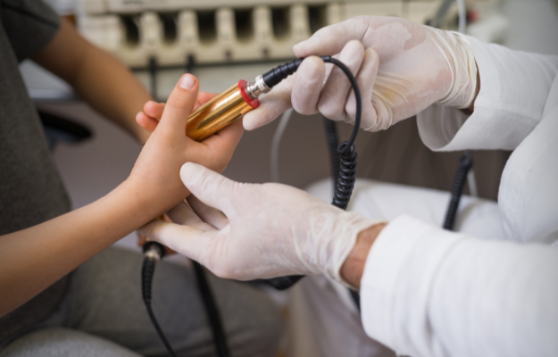 Biorezonans - specjalista podaje dziecku elektrodę w ramach sesji biorezonansu
