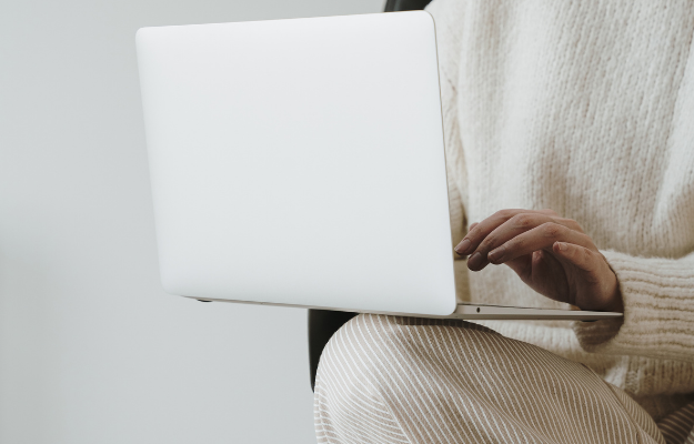 O nas - kobieta siedzi na krześle i używa laptopa